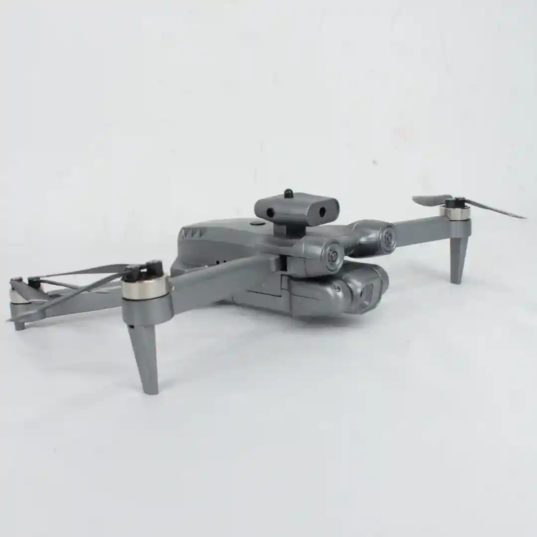 Cuadricóptero plegable gris con cámara frontal y sensores laterales, diseñado para grabación aérea y navegación segura.
