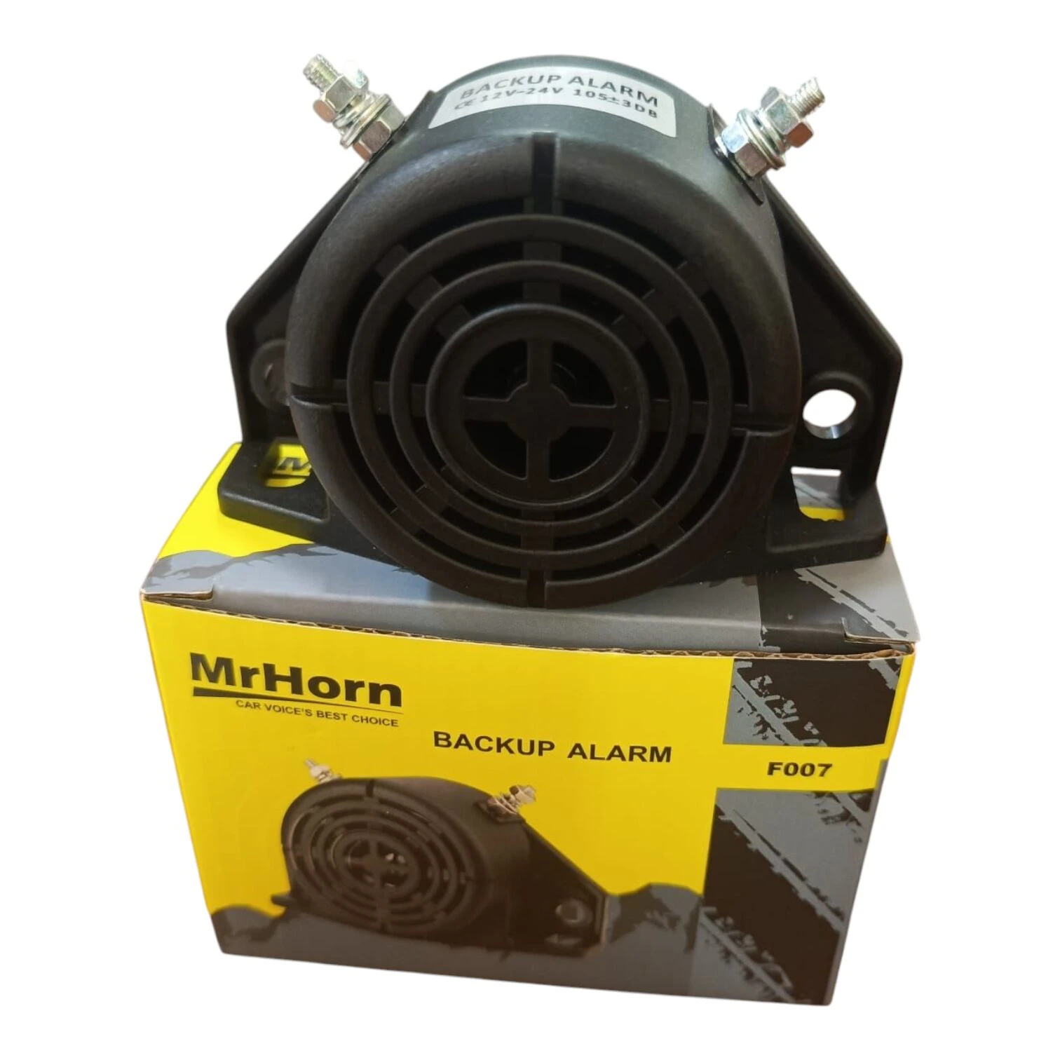Pito de reversa automático negro con carcasa plástica y base metálica, sobre su caja amarilla que indica modelo F007.