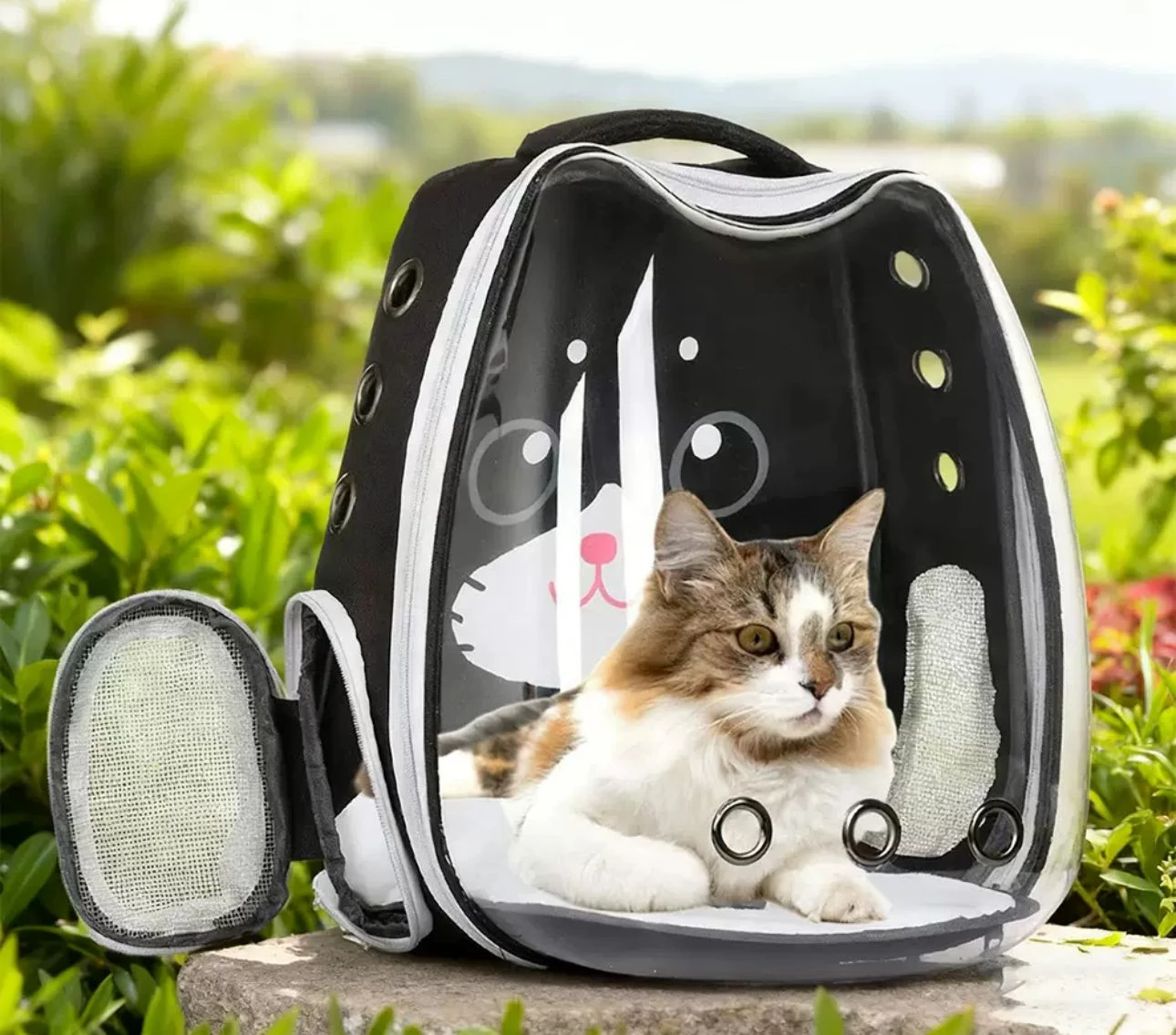 Mochila tipo cápsula para mascotas de hasta 12 kg, color negro con detalles blancos, con panel frontal transparente y una gata acostada dentro.
