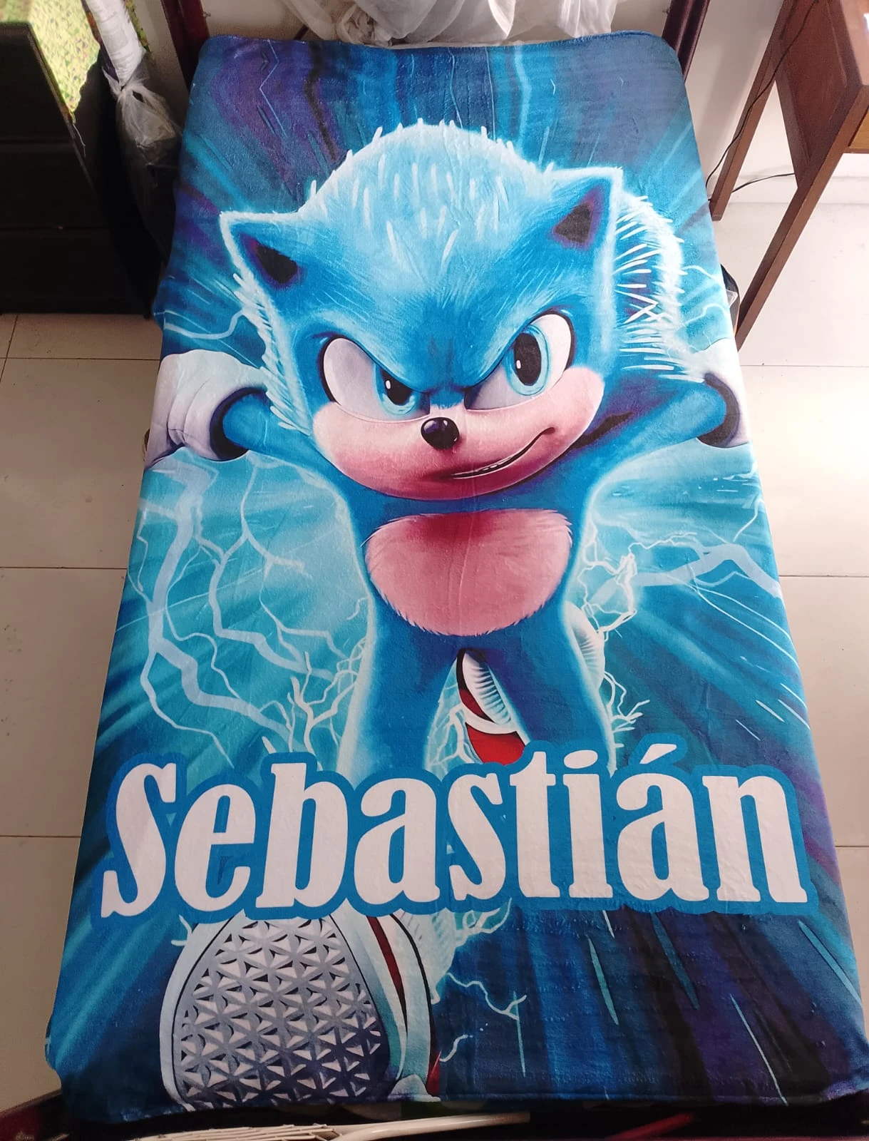 Cobija personalizada de 1,40m con diseño de Sonic the Hedgehog y nombre "Sebastián" en letras blancas sobre fondo azul eléctrico.