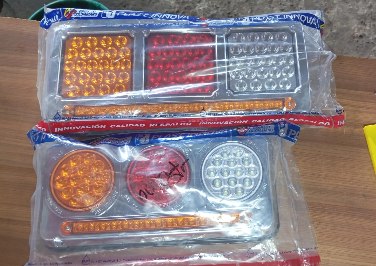 Dos regletas Stoptriple redondas con 92 LEDs, una en amarillo y otra en rojo, mostrando sus luces frontales y traseras en empaque transparente.