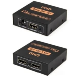 Adaptador HDMI 1x2 activo en caja negra, mostrando puerto de entrada y dos salidas, con etiquetas UHD 4Kx2K 3D.