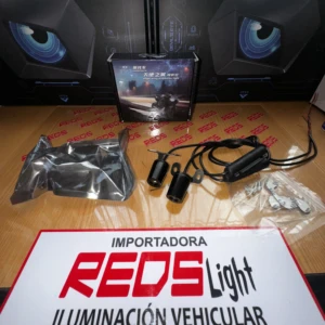Kit de luces LED para vehículo con cables, conectores y accesorios en caja, sobre mesa con cartel de importadora.