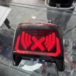 Luz de freno LED roja para moto Boxer CT, diseño con símbolo X y luces laterales, sin soldar cables, sobre mostrador de vidrio.