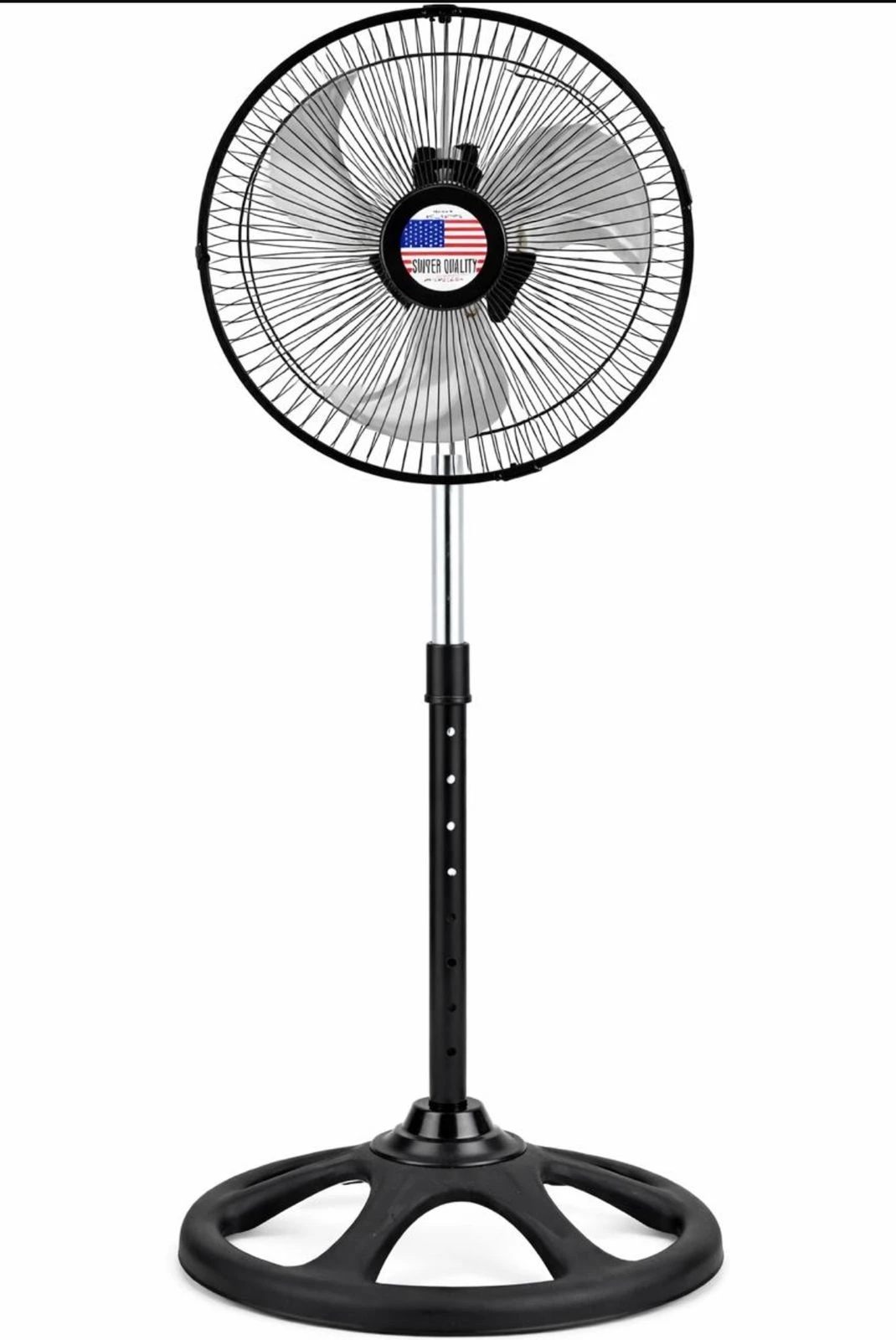 Ventilador de pedestal negro con base regulable y tres aspas, mostrando bandera estadounidense en el centro del motor.