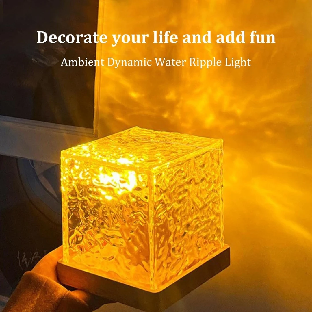 Lámpara solar en forma de cubo de hielo, color ámbar, con textura rugosa que proyecta reflejos dinámicos sobre la pared.