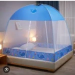 Toldillo tipo casa con malla azul y estampado de ballenas, instalado sobre cama con colchón blanco y almohada.