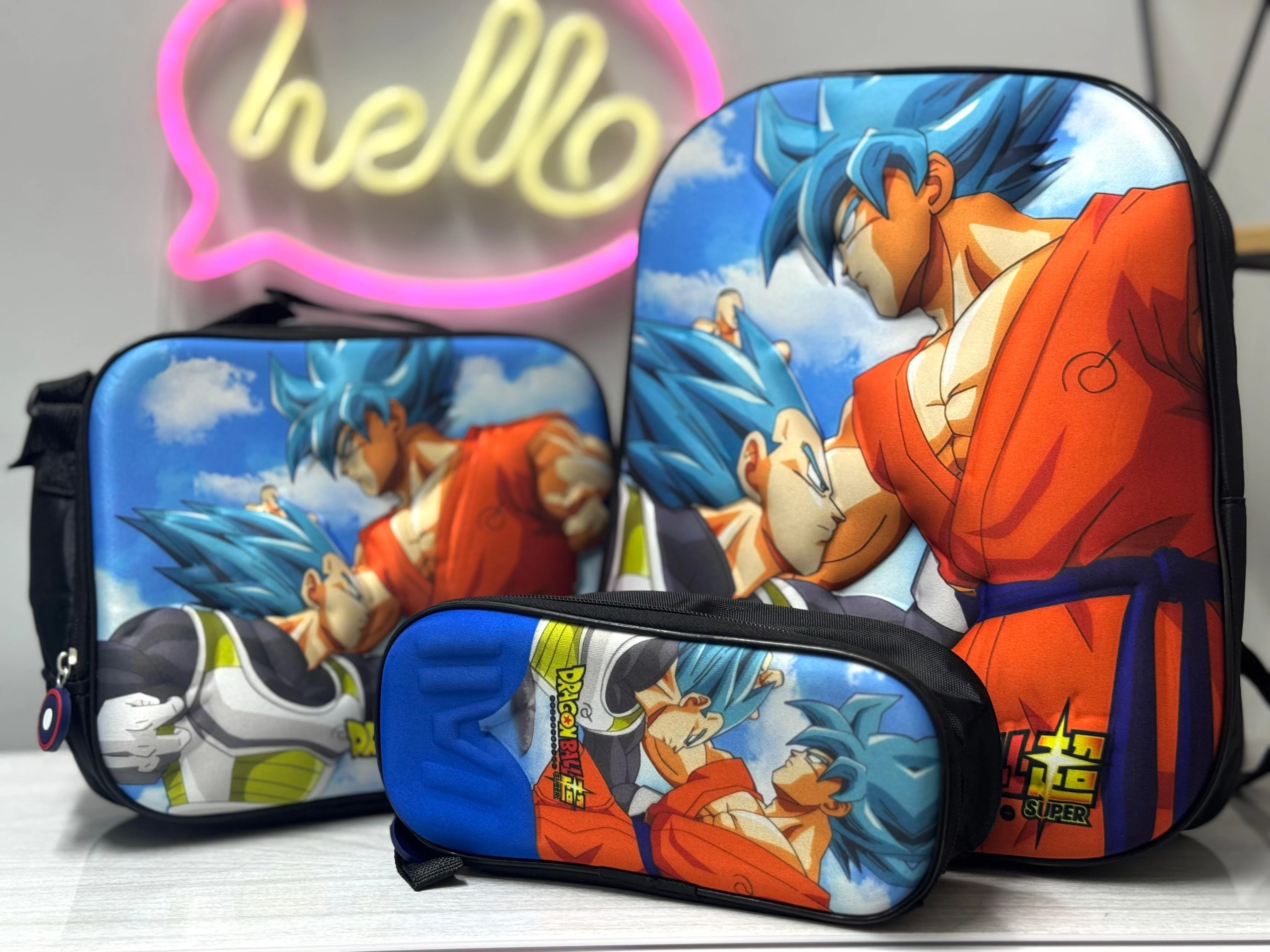 Set de tres accesorios escolares con lona 3D de Goku en Super Saiyan Azul, mostrando mochila, estuche y bolsa térmica con diseño coherente.