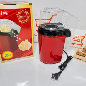 Crispetera mini eléctrica roja con tapa transparente, cable negro y caja de cartón al lado.