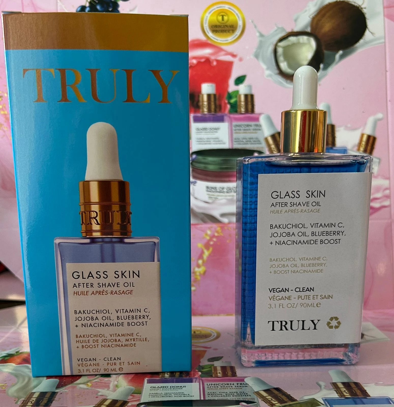 Set de dos botellas de aceite corporal Glass Skin de Truly, con dropper blanco y etiqueta azul claro; incluye caja y botella transparente con líquido azul.