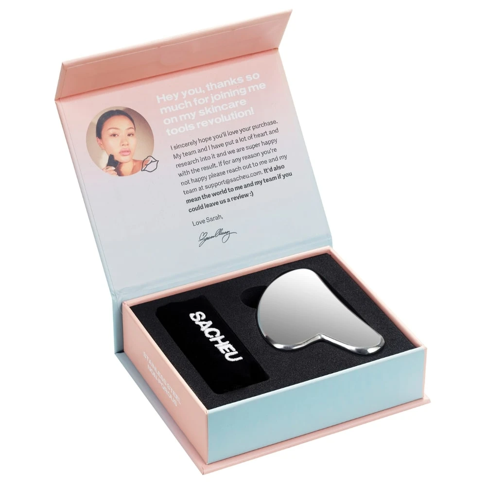 Set de dos guasha facial de jade en caja rosa con tarjeta de agradecimiento y estuche negro que muestra el mango con la marca SACHELI.