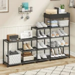 Zapatera organizadora de metal negro con cinco niveles, mostrando zapatos, cajas y accesorios en interior con pared blanca y suelo de madera.