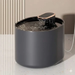 Bebedero automático para mascotas en color gris oscuro, con tapa negra y dispensador de agua en funcionamiento sobre superficie blanca.