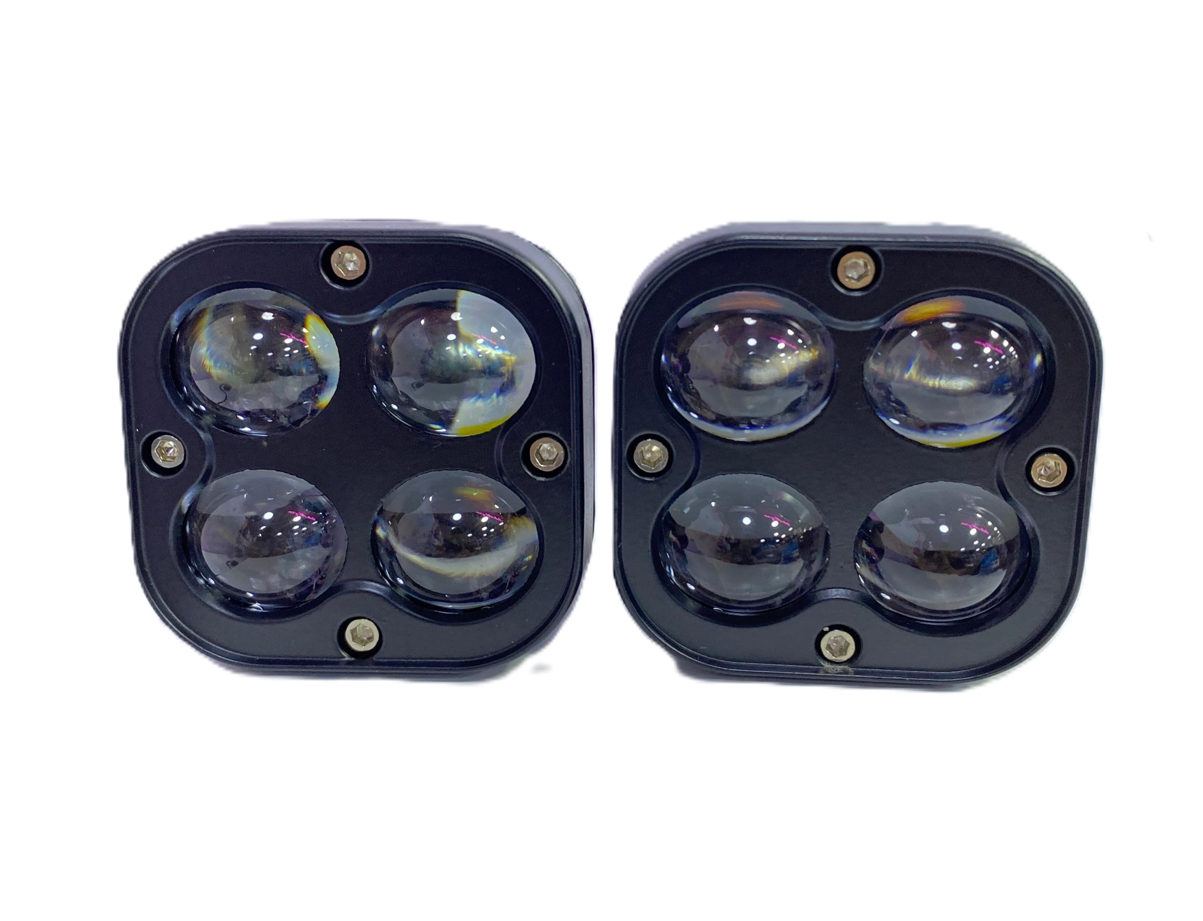 Dos faros cuadrados de color negro con cuatro lentes redondas, uno a la izquierda y otro a la derecha, sobre fondo blanco.