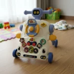 Andadera robot Kidshop color crema con detalles azules y amarillos, ruedas azules, volante amarillo y panel de actividades frontal.