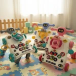Tres andaderas tipo robot en colores rosa, azul y verde, con mesas de actividades interactivas y ruedas, sobre alfombra infantil con patrón de animales.