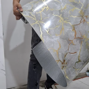 Rollo acolchado marmolizado con vetas doradas, siendo manipulado por una persona en interior.
