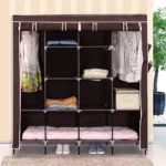 Ropero tela plegable de cuatro cuerpos en color marrón, con estructura metálica y estantes organizados con prendas, ropa doblada, cajón y colchón inferior.