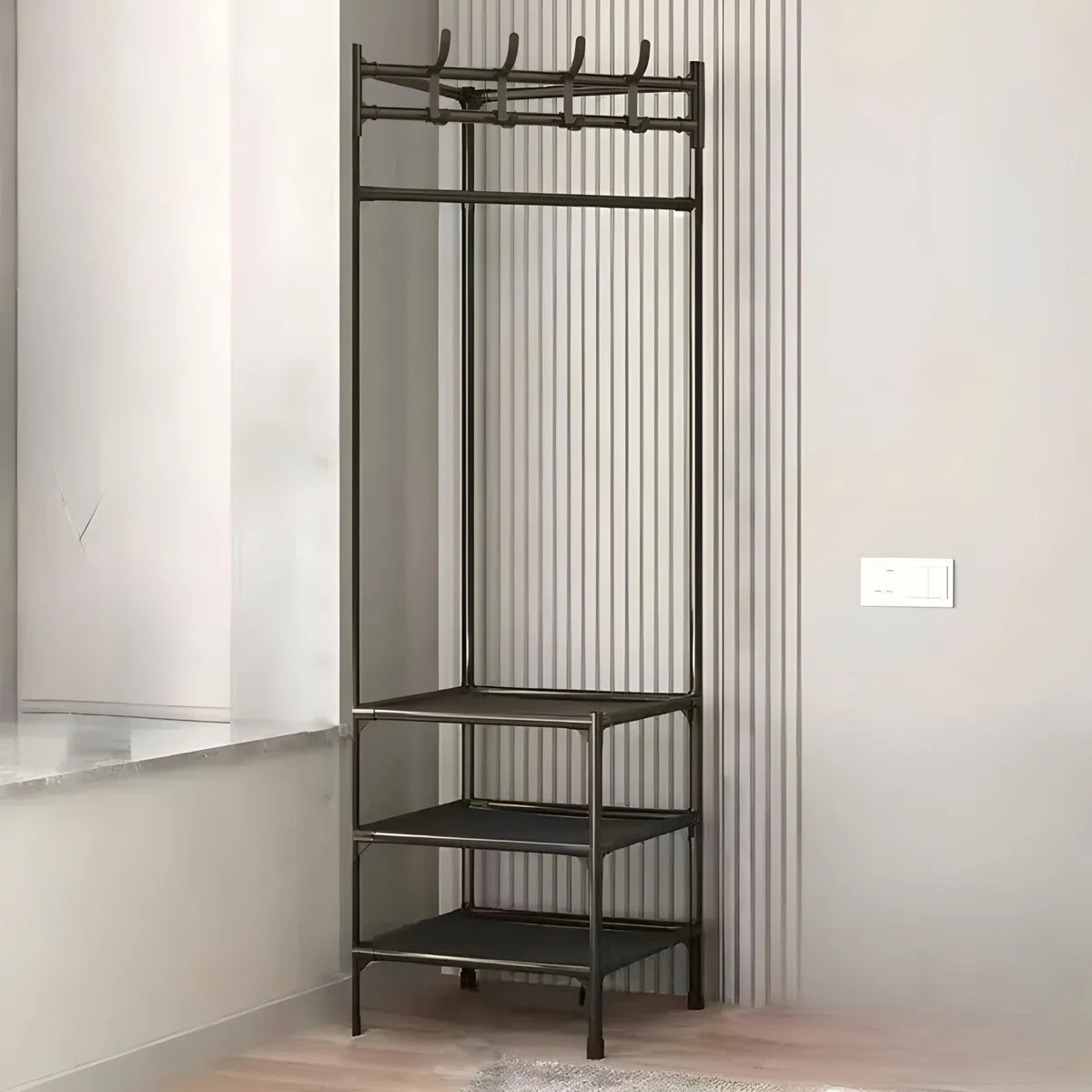 Perchero metálico negro con tres estantes y ganchos superiores, ideal para organizar abrigos y calzado en rincones.