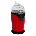 Crispetera de aire compacta en rojo con tapa transparente y base negra, diseñada para preparar palomitas sin aceite.
