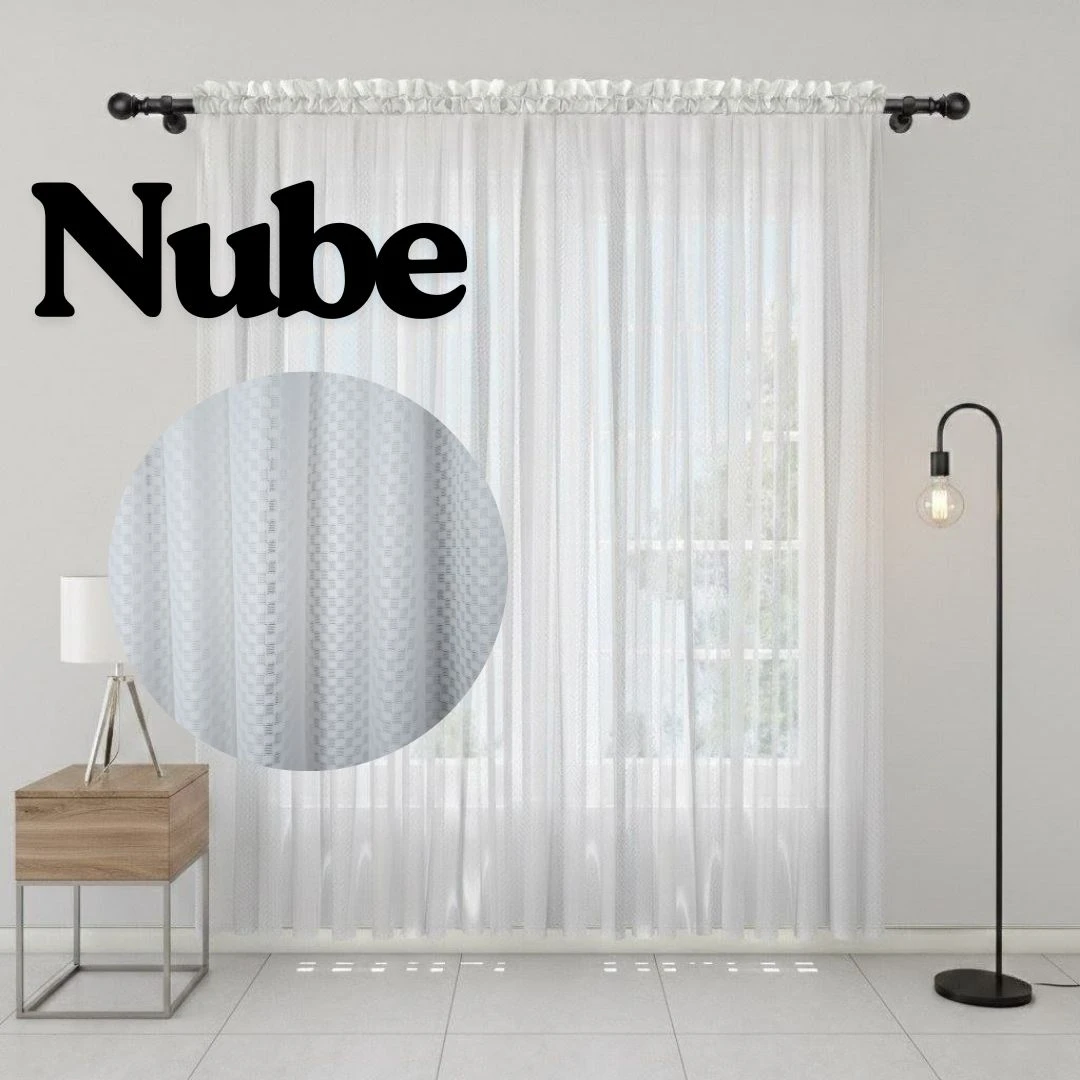 Cortina de velo muselina blanca, modelo Nube, con textura visible en primer plano. Incluye varilla de montaje y se muestra colgada en sala con lámpara y mueble lateral.