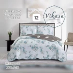 Colcha Vikasa cama doble, estampado floral azul sobre fondo claro, con reverso gris; incluye dos almohadas y funda de edredón. Medidas 220x240 cm.
