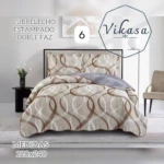 Colcha Vikasa cama doble, doble faz con estampado geométrico en tonos beige y marrón, vista frontal con cojines y sábanas a juego. Medidas 220x240 cm.