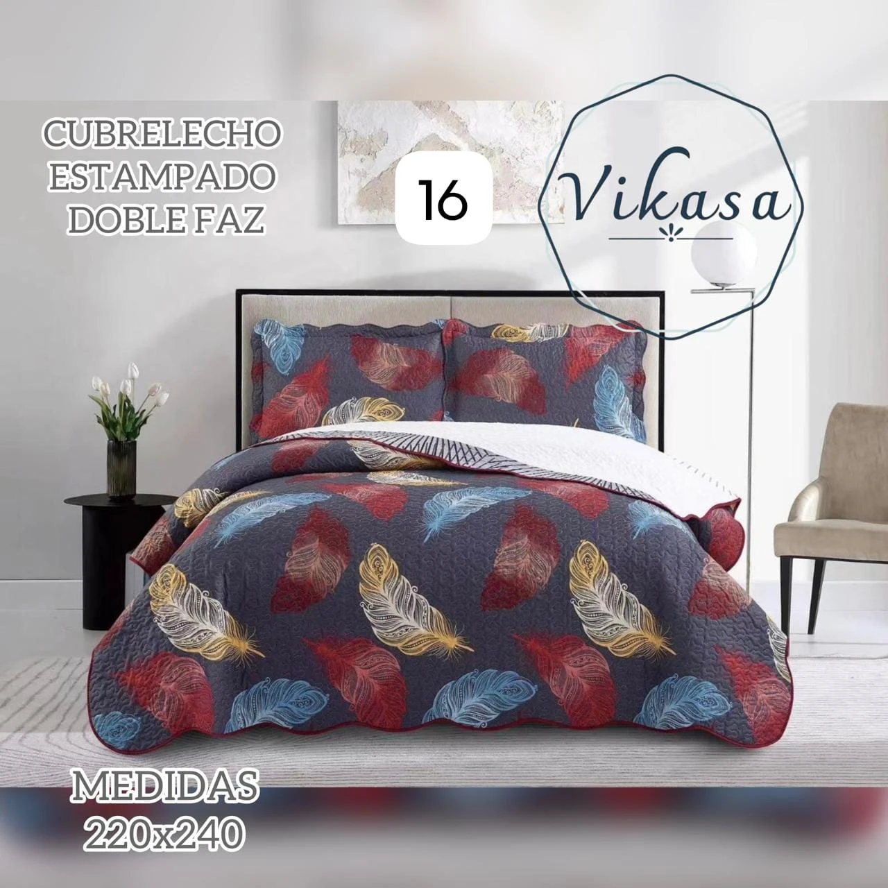 Colcha Vikasa cama doble de doble faz, estampada con plumas en tonos rojos, azules y dorados sobre fondo gris oscuro. Medidas 220x240 cm.