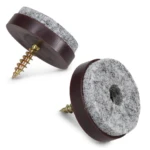 Dos almohadillas antideslizantes con tornillo para muebles, una vista frontal y otra lateral, mostrando su base de goma oscura, tapete gris texturizado y tornillo dorado.