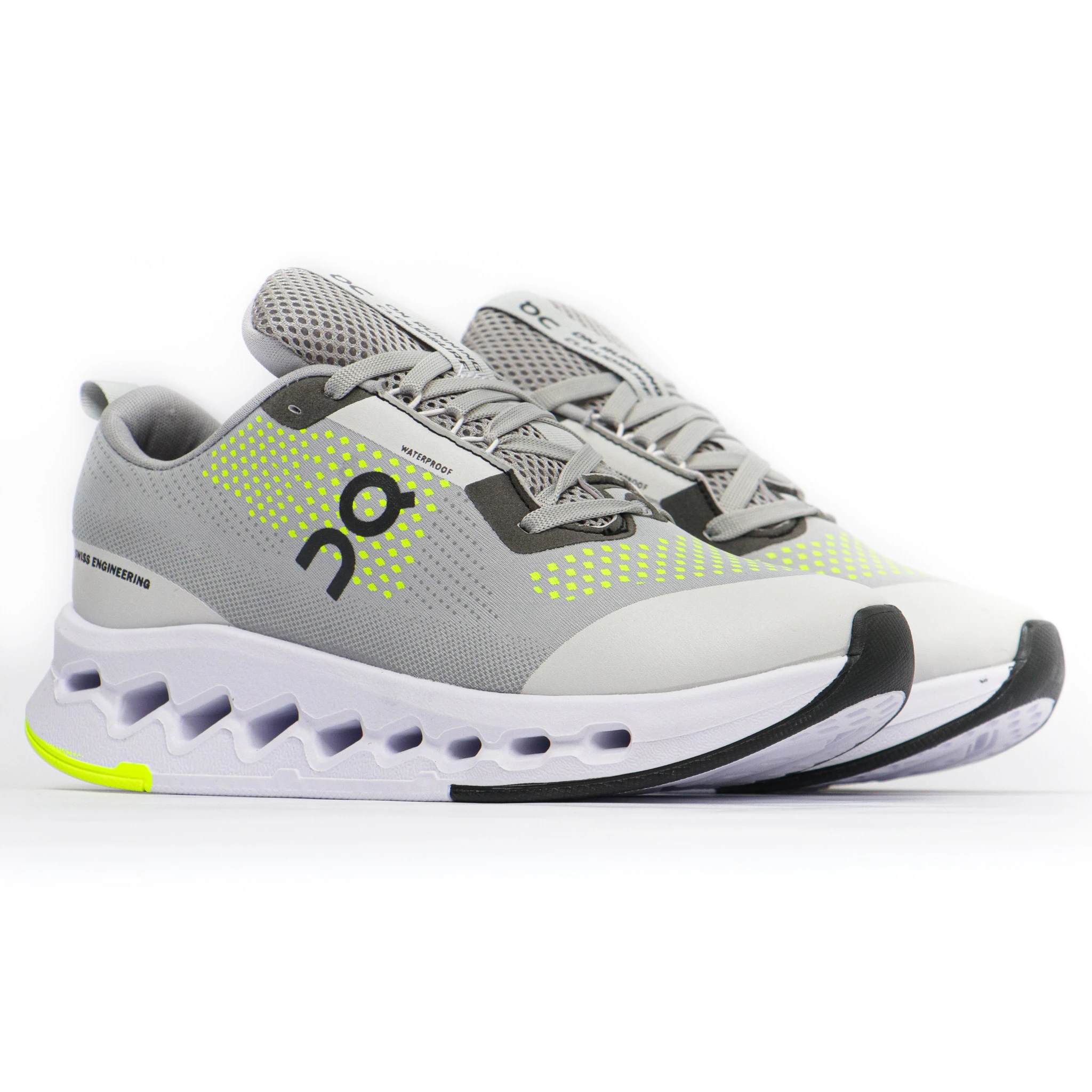 Zapatilla deportiva On6 en gris con detalles en amarillo neón, suela segmentada y malla transpirable, vista lateral sobre fondo blanco.