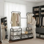 Perchero de metal negro con tres niveles: ganchos superiores para abrigos y estantes inferiores para zapatos y cajas organizadoras.