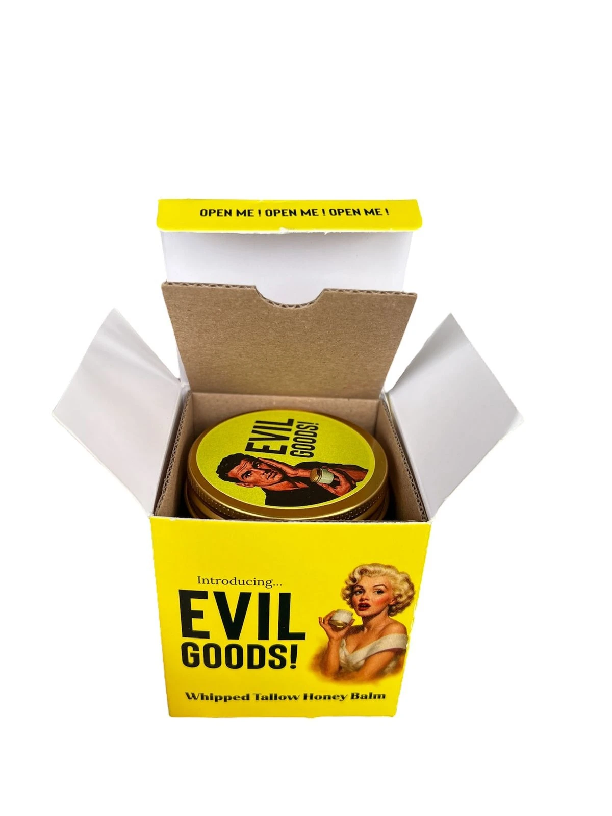Caja amarilla abierta mostrando bálsamo Evil Goods con sebo de res y miel, envase redondo con etiqueta ilustrada de Marilyn Monroe y texto en inglés.