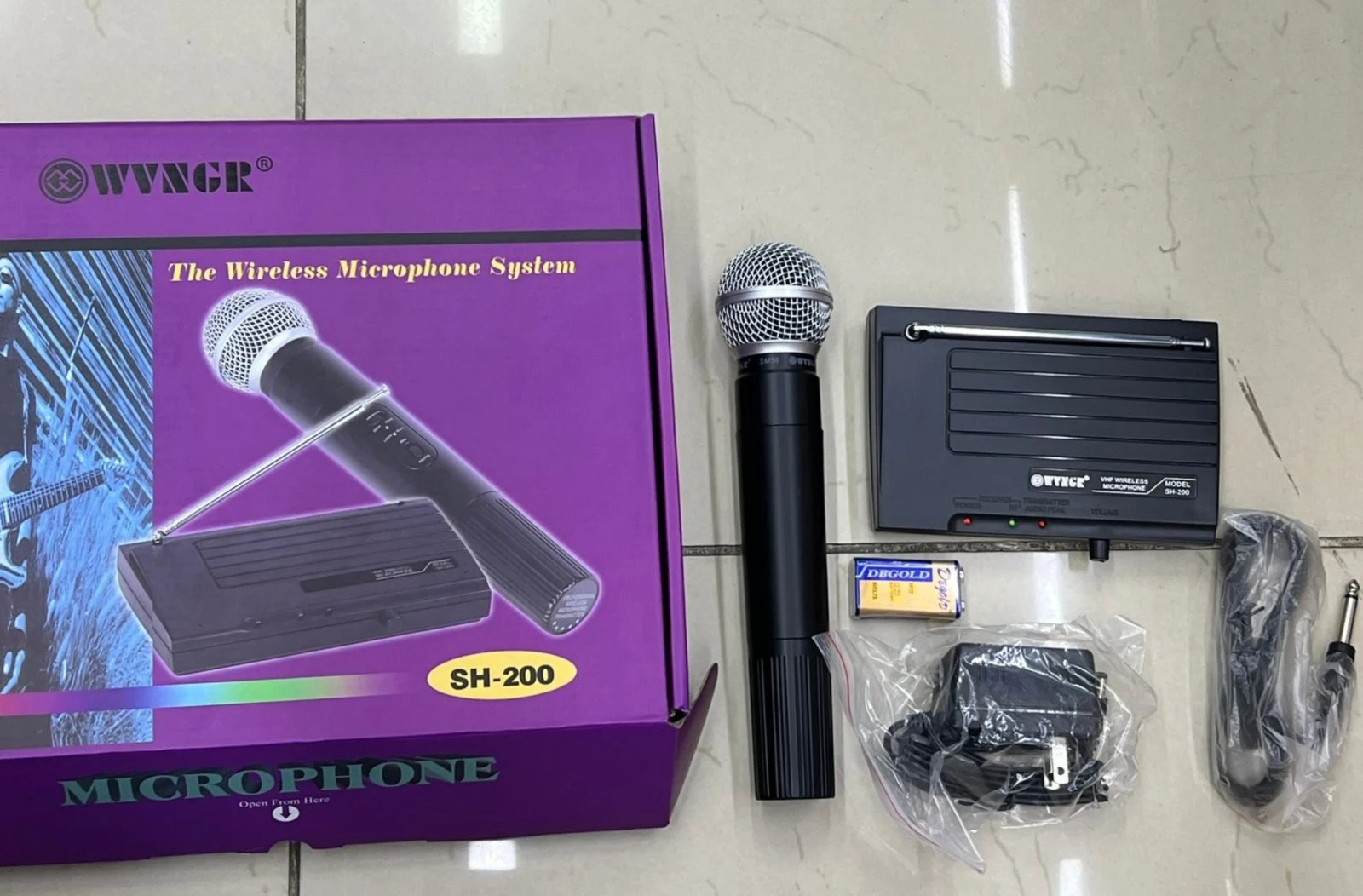 Pack de micrófono inalámbrico Wyngir SH-200 en caja morada, incluye micrófono negro con antena retráctil, receptor, cargador y cables.