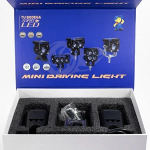 Caja abierta de luces LED para vehículos, mostrando tres unidades negras en interior con espuma protectora y accesorios incluidos.