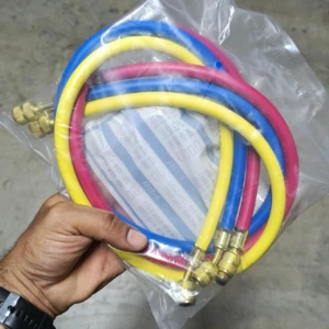 Kit de manómetros para refrigerantes R410, R22, R404 y R134A en bolsa plástica transparente, con mangueras azul, roja y amarilla y conexiones metálicas doradas.