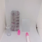 Kit de decoración para uñas con piedras y estampador. Incluye organizador transparente con accesorios, tóner rosa, base de silicona y rodillo para estampado.