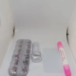 Kit de decoración para uñas con piedras y estampador. Incluye caja de compartimentos con pedrería, rodillo de silicona, plantilla y marcador rosa.