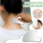 Gua sha de acero quirúrgico plateado, con forma ergonómica y bordes redondeados, usado en el cuello y rostro para masaje facial y definición de contornos.