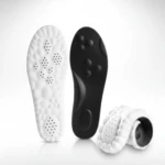 Plantillas deportivas acolchadas en blanco y negro, con base antideslizante y perforaciones para ventilación. Presentación de dos unidades, una enrollada, mostrando textura y diseño ergonómico.