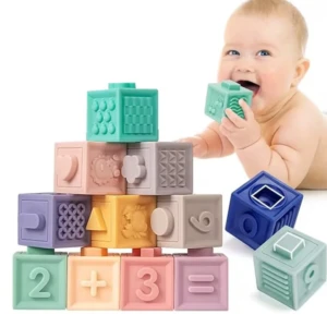 Bloques de construcción de silicona en colores pastel con formas geométricas, números y símbolos matemáticos, apilados en pirámide y siendo mordidos por un bebé.