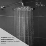Regadera redonda Acora de acero inoxidable en uso, con gotas cayendo uniformemente sobre fondo de baldosas oscuras. Diseño minimalista y elegante.
