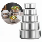 Set de cinco recipientes de acero inoxidable con tapas, apilados en orden descendente de tamaño, mostrando su brillo metálico y diseño funcional para almacenamiento de alimentos.