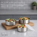 Set de tres bowls de acero inoxidable Acora con tapas, mostrando ensaladas y pasta en un tablero de madera sobre encimera gris.