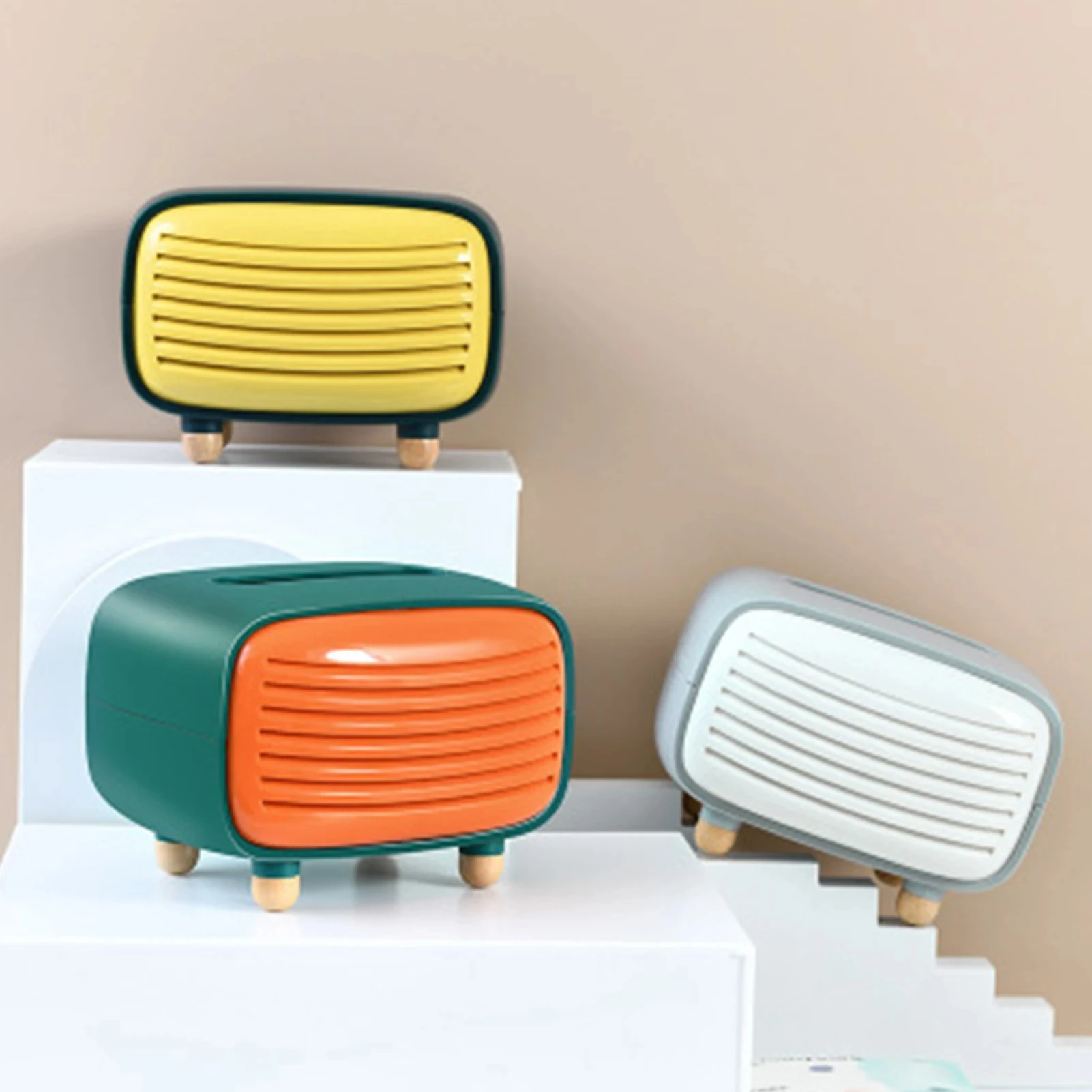 Dispensador de servilletas estilo radio retro en tres colores: amarillo, naranja y blanco, con base de madera y diseño vintage.