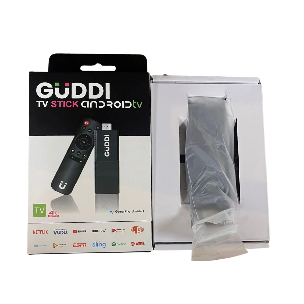 Pack de TV Stick Guddi con caja y control remoto negro, mostrando logotipos de plataformas como Netflix y Vudu.