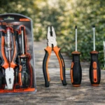 Kit de herramientas manuales con probador de voltaje, incluye alicates, destornilladores y detector de corriente, presentados en blister con mango naranja y negro sobre superficie de madera.