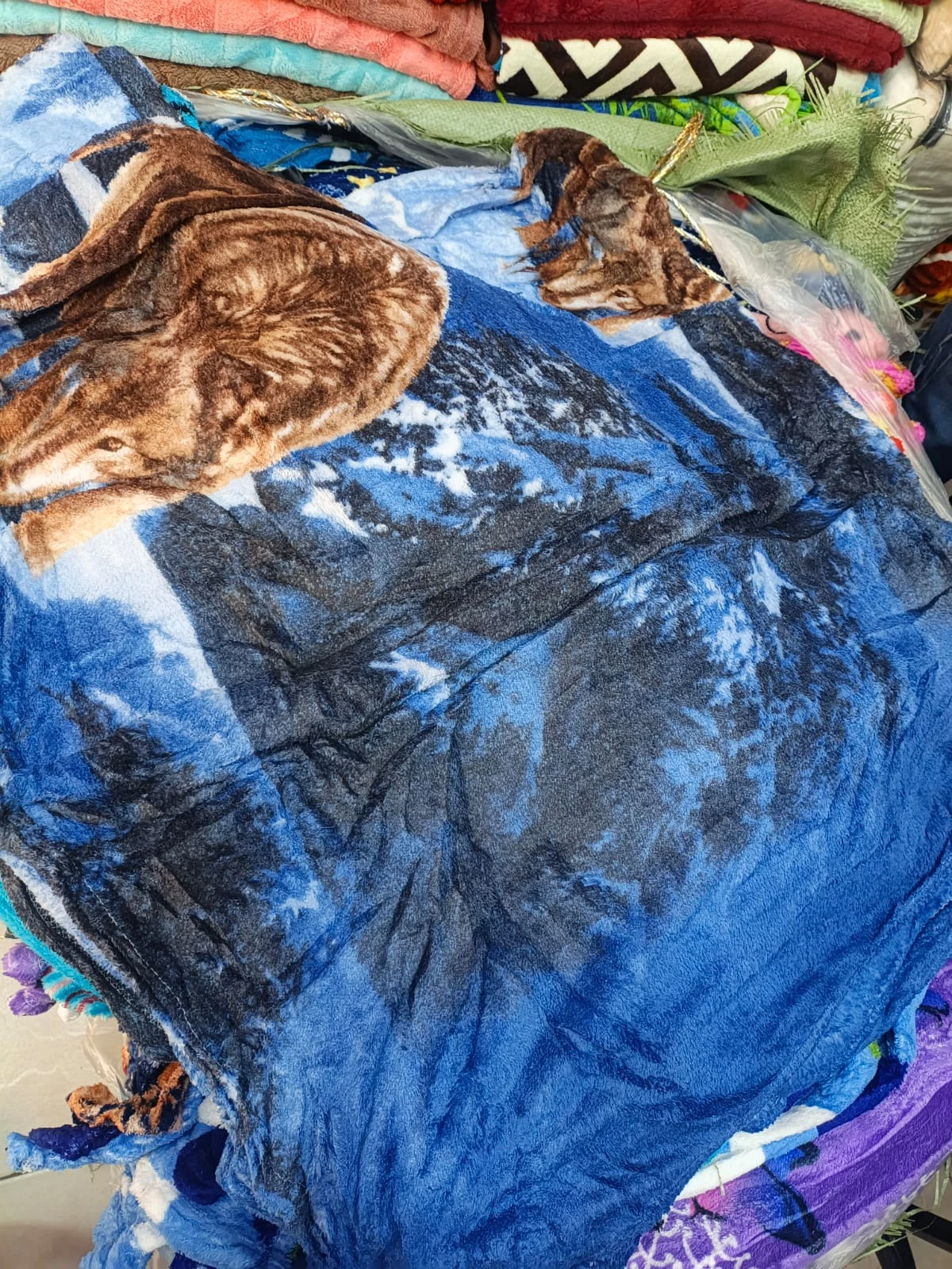 Cobija térmica azul con estampado de ciervo, textura suave y bordes decorativos, ideal para cama doble.