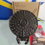 Parrilla arepas Victoria de hierro fundido con superficie perforada y empuñaduras metálicas, mostrada sobre su caja original.