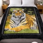 Manta térmica con diseño de tigre en postura relajada, bordes negros con patrón geométrico, usada sobre cama con cabecero tapizado y mesitas de noche.