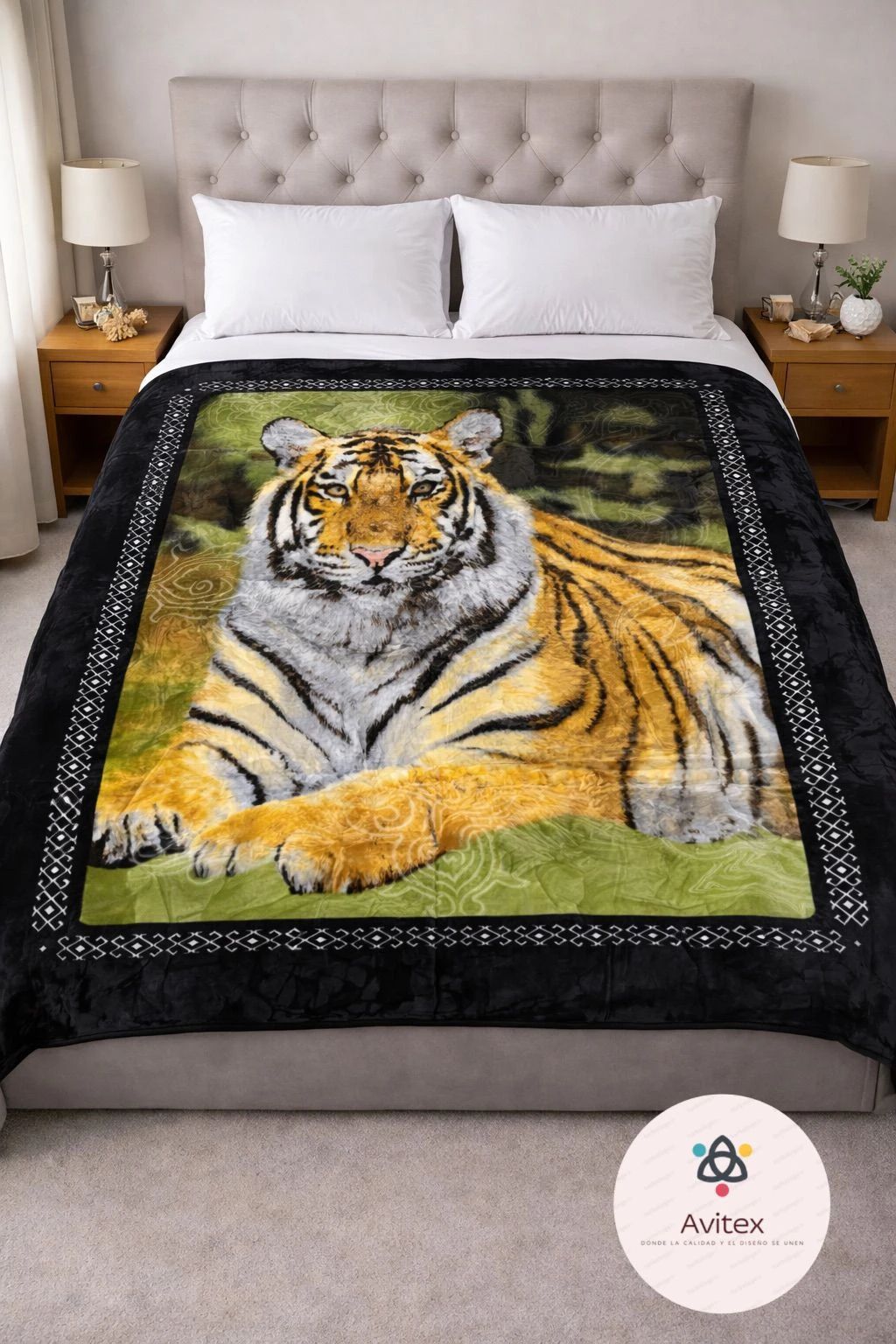 Manta térmica con diseño de tigre en postura relajada, bordes negros con patrón geométrico, usada sobre cama con cabecero tapizado y mesitas de noche.